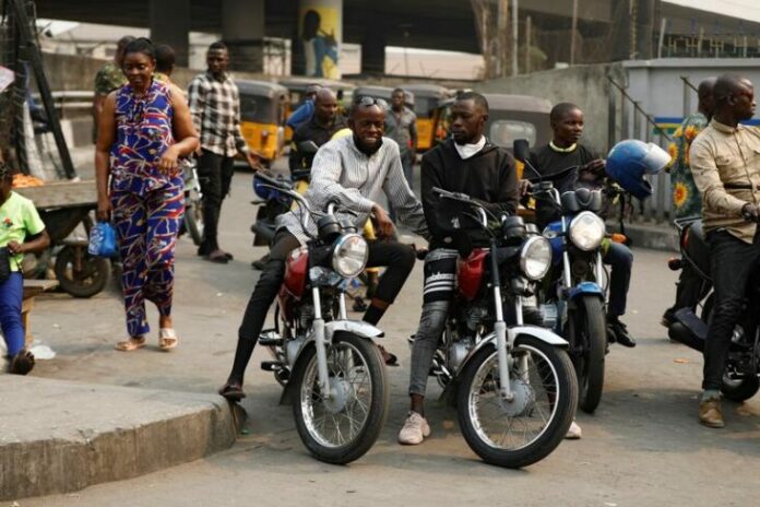 Motorcycle taxi drivers sit on their bikes, popularly called